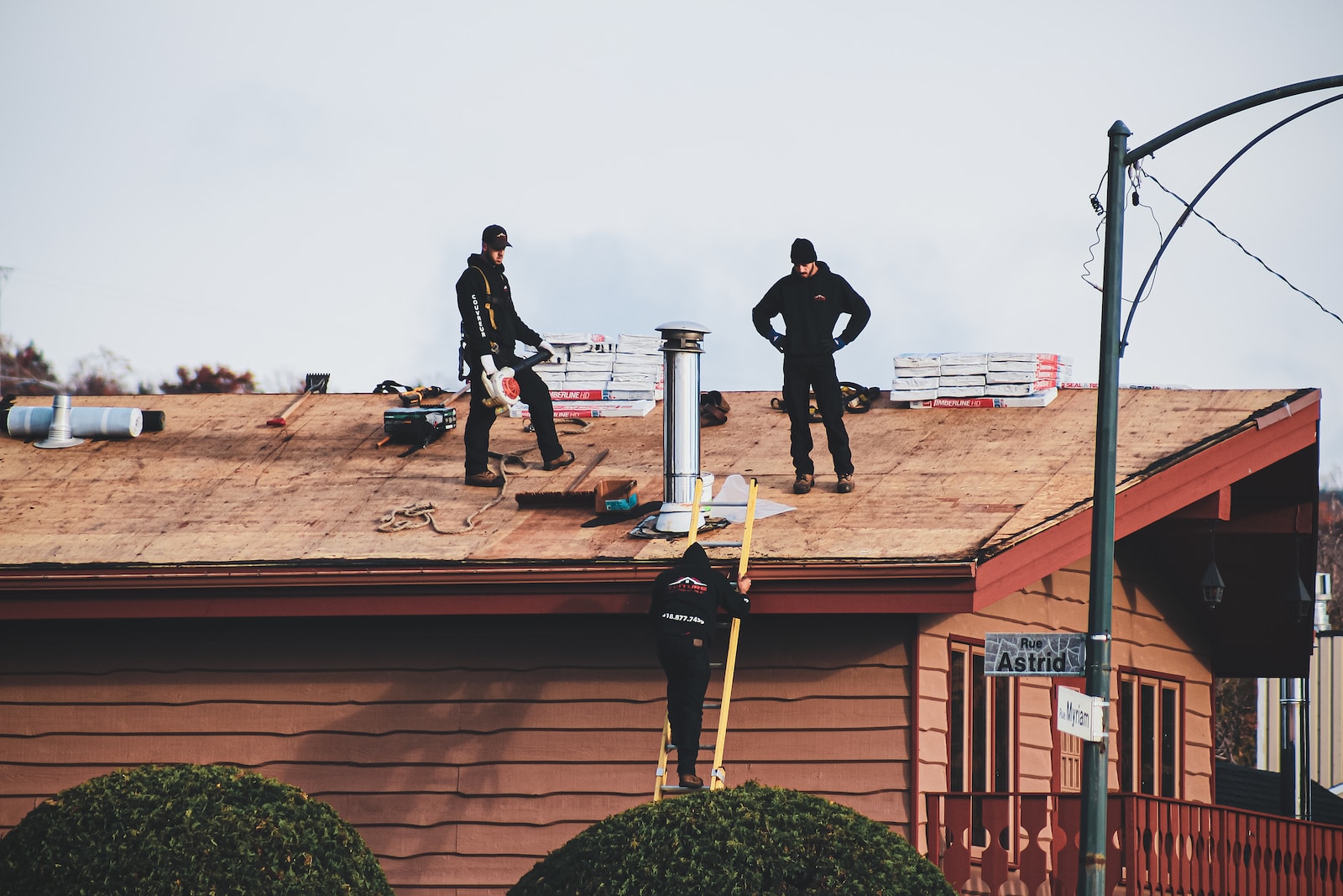 a couple of men standing on top of a roof